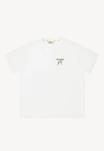 Oversizowy T-shirt z logowaną kokardką TISHALLE kremowy